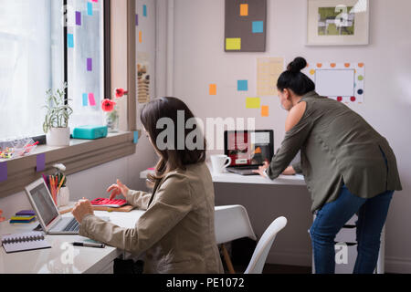 Fashion designers working on laptop in design studio Stock Photo