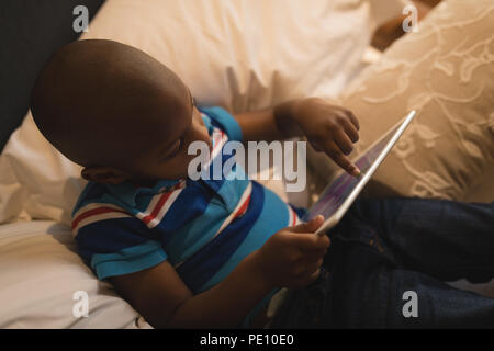 Boy playing with digital tablet in bedroom Stock Photo