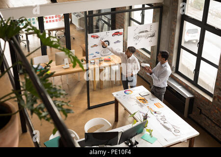 Business colleagues discussing over chart Stock Photo