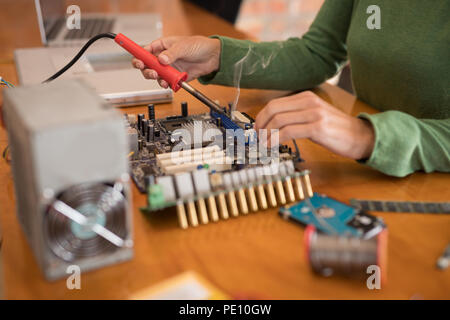 Female electrical engineer soldering a circuit board Stock Photo