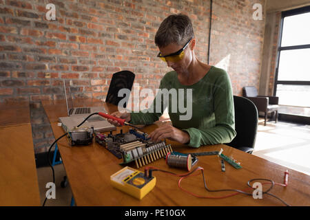 Female electrical engineer soldering a circuit board Stock Photo