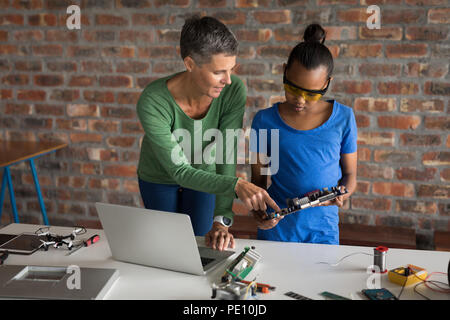 Mother explaining her daughter about circuit board Stock Photo