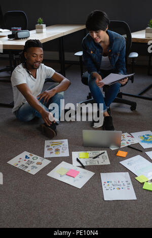 Colleagues discussing over documents Stock Photo