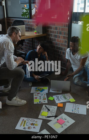 Colleagues discussing over documents Stock Photo