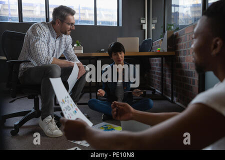 Colleagues discussing over documents Stock Photo