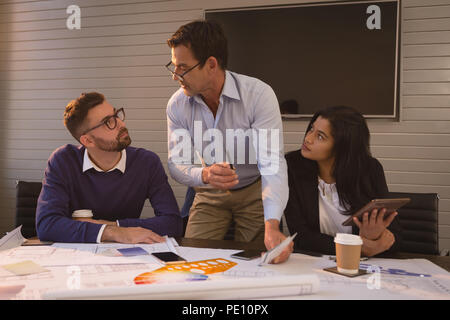 Business people discussing blueprint and graph chart Stock Photo