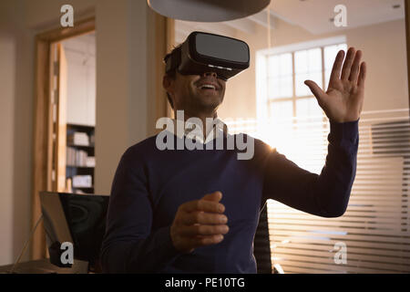Businessman using virtual reality headset in the office Stock Photo