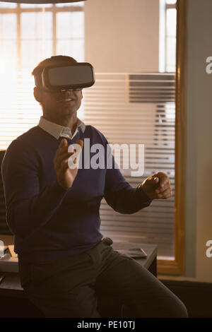 Businessman using virtual reality headset in the office Stock Photo