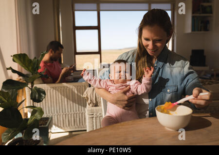 Baby boy crying while mother feeding him food Stock Photo