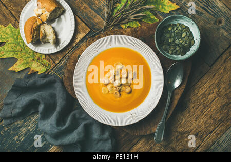 Warming pumpkin cream soup with croutons and seeds in plate Stock Photo