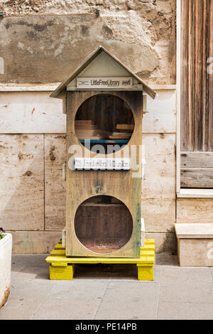 free library on a pallet in a street in alghereo on the street for everyone to use for borrowing books, Stock Photo