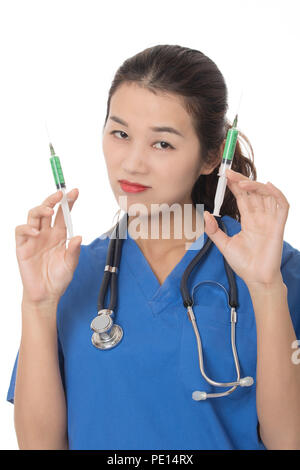 Evil Asian doctor or nurse holding a syringe filled with green medication isolated on a white background Stock Photo