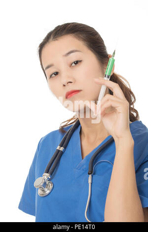 Evil Asian doctor or nurse holding a syringe filled with green medication isolated on a white background Stock Photo