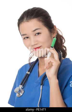 Evil Asian doctor or nurse holding a syringe filled with green medication isolated on a white background Stock Photo