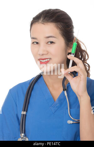 Evil Asian doctor or nurse holding a syringe filled with green medication isolated on a white background Stock Photo