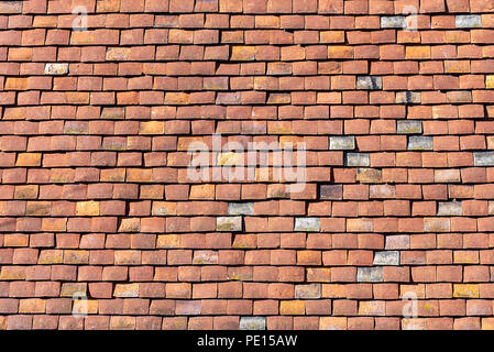 Background from a house wall made of red old shingles Stock Photo