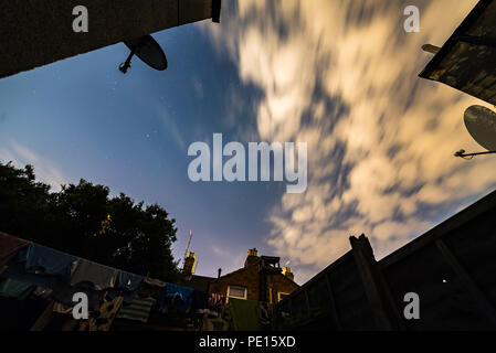 Night stars sky view from British backyard with laundry and satelite dishes around it. Stock Photo