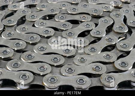 A meticulously arranged bicycle chain rests gracefully on a pristine white background. Stock Photo