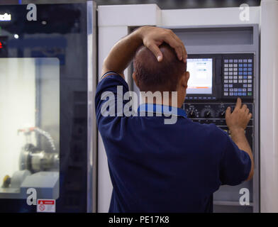 Industrial worker input data programing for CNC lathing machine Stock Photo