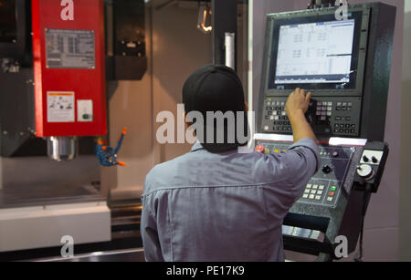 Industrial worker input data programing for CNC milling machine Stock Photo