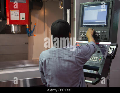 Industrial worker input data programing for CNC milling machine Stock Photo