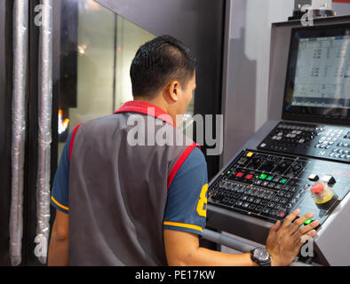 Industrial worker input data programing for CNC milling machine Stock Photo