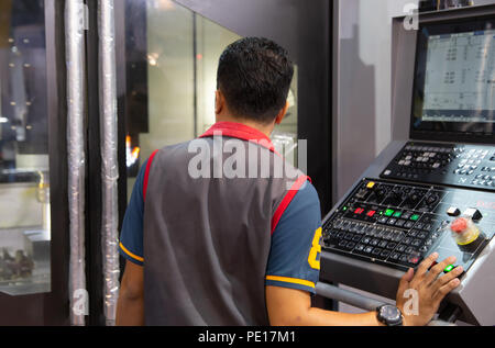 Industrial worker input data programing for CNC milling machine Stock Photo