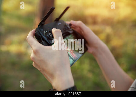 Remote control for quadrocopter, close-up. Transmitter for controlling moving device in male hands, blurred nature background. Electronics, hobby, aer Stock Photo