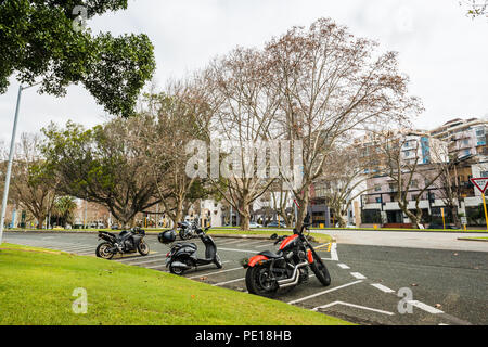 Three parking motorcycles on a parking lot, parking space in Perth, western Australia, Oceania Stock Photo