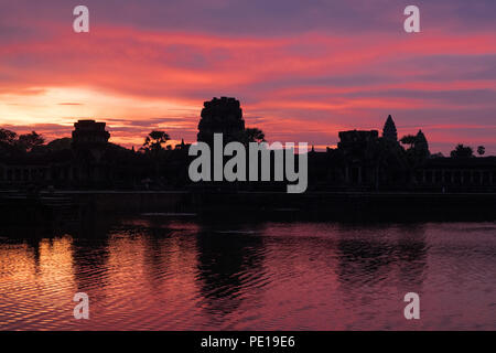 Sunrise over the moat surrounding the temple Angkor Wat - the largest religious monument in the world - near Siem Reap, Cambodia Stock Photo