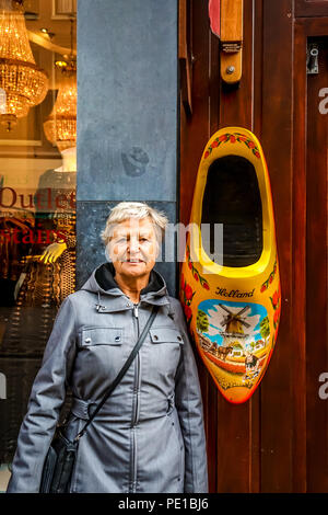 Large wooden shoe, painted in traditional Dutch pattern and colors, hanging outside souvenir shop in the Leidsestraat in historic Amsterdam, Holland Stock Photo