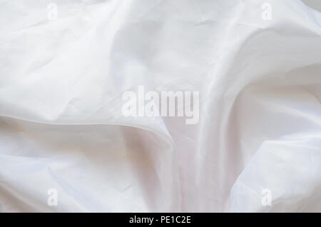 White Synthetic Lining Fabric with Folds. Crumpled Sheet or Clothes Background, Stock Photo