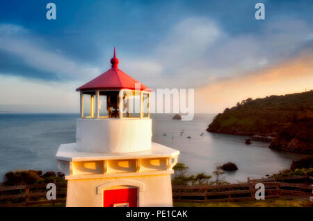 Trinidad Lighthouse with boats in harbor and sunset. California Stock Photo