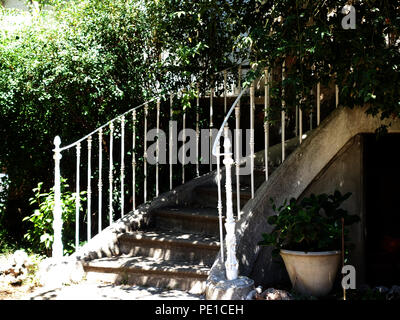 Shaded steps leading up to hidden front door of a townhouse in Cessenon-sur-Orb, France