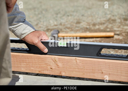 Construction worker using  a bubble level to level the cement form boards with shallow depth of field Stock Photo