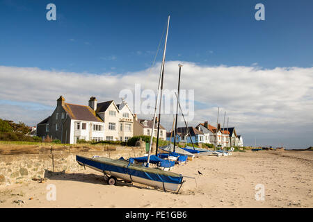 UK, Wales, Anglesey, Rhosneigr, boats on beach at seafront houses Stock Photo