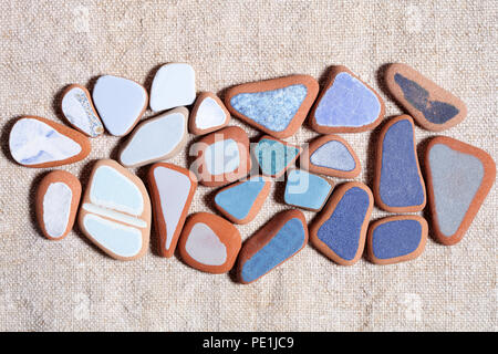 pieces of colorful tiles polished by the sea closeup on textile background Stock Photo