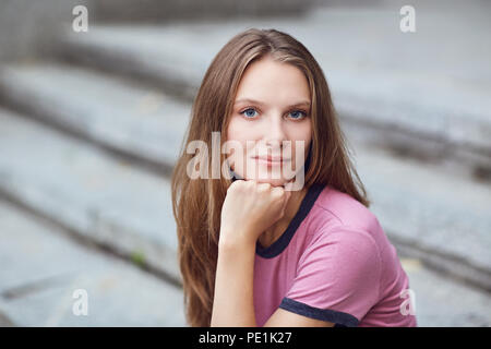 A blonde girl in a serious mood on a  street. Stock Photo