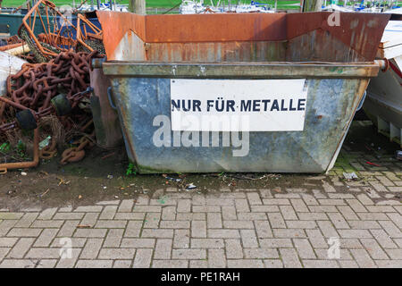 Scrap containers with inscription and old rusted ship chains on a junkyard in the port of Carolinensiel in East Frisia. Stock Photo