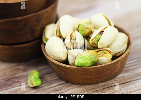 Close up of pistachio nuts in wooden bowl Stock Photo