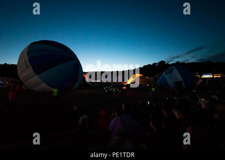 Night Glow in the evening of the Bristol International Balloon Fiesta. A number of balloons performed at night to music using their gas burners Stock Photo