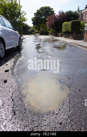 Bexley, London, UK. 11th August 2018. Recent heatwave causes pothole and broken water pipe in Upton Road South, Bexley in South East London. Steve Hickey/AlamyLive News Stock Photo