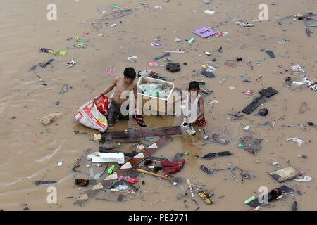 Marikina City, Philippines. 12th Aug, 2018. Kids wade through the flood brought by tropical storm Yagi as they look for their belongings in Marikina City, the Philippines, Aug. 12, 2018. Credit: Rouelle Umali/Xinhua/Alamy Live News Stock Photo