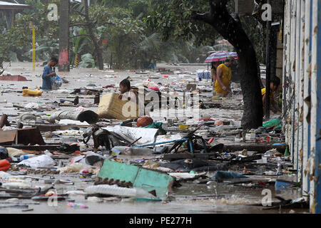 Marikina City, Philippines. 12th Aug, 2018. Residents wade through the flood brought by tropical storm Yagi as they look for their belongings in Marikina City, the Philippines, Aug. 12, 2018. Credit: Rouelle Umali/Xinhua/Alamy Live News Stock Photo