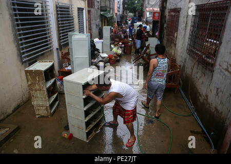 Marikina City, Philippines. 12th Aug, 2018. Residents clean mud and debris after the flood in Marikina City, the Philippines, Aug. 12, 2018. Tropical storm Yagi enhanced the monsoon causing continous rain and flooding in parts of Metro Manila. Credit: Rouelle Umali/Xinhua/Alamy Live News Stock Photo