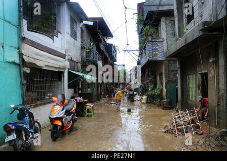 Marikina City, Philippines. 12th Aug, 2018. Residents clean mud and debris after the flood in Marikina City, the Philippines, Aug. 12, 2018. Tropical storm Yagi enhanced the monsoon causing continous rain and flooding in parts of Metro Manila. Credit: Rouelle Umali/Xinhua/Alamy Live News Stock Photo