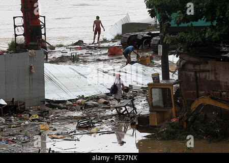 Marikina City, Philippines. 12th Aug, 2018. Residents clean mud and debris after the flood in Marikina City, the Philippines, Aug. 12, 2018. Tropical storm Yagi enhanced the monsoon causing continous rain and flooding in parts of Metro Manila. Credit: Rouelle Umali/Xinhua/Alamy Live News Stock Photo