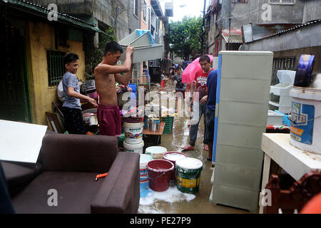 Marikina City, Philippines. 12th Aug, 2018. Residents clean mud and debris after the flood in Marikina City, the Philippines, Aug. 12, 2018. Tropical storm Yagi enhanced the monsoon causing continous rain and flooding in parts of Metro Manila. Credit: Rouelle Umali/Xinhua/Alamy Live News Stock Photo