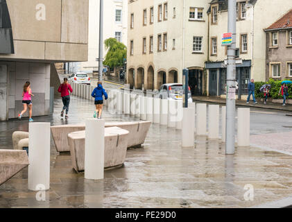 Holyrood, Edinburgh, Scotland, United Kingdom, 12th August 2018. UK Weather: the rain and mist as the remnants of Storm Debby hits the capital does not deter joggers running at the Scottish Parliament building at the bottom of Canongate on the Royal Mile Stock Photo