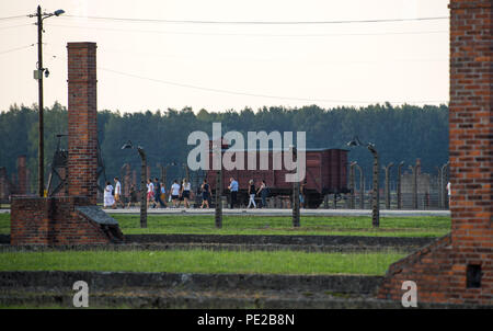 Oswiecim, Poland. 09th Aug, 2018. Visitors pass a historic wagon on the grounds of the former Auschwitz-Birkenau extermination camp. From 1940 to 1945, the SS operated the Auschwitz complex with numerous subcamps as extermination and concentration camps. Credit: Monika Skolimowska/dpa-Zentralbild/dpa/Alamy Live News Stock Photo